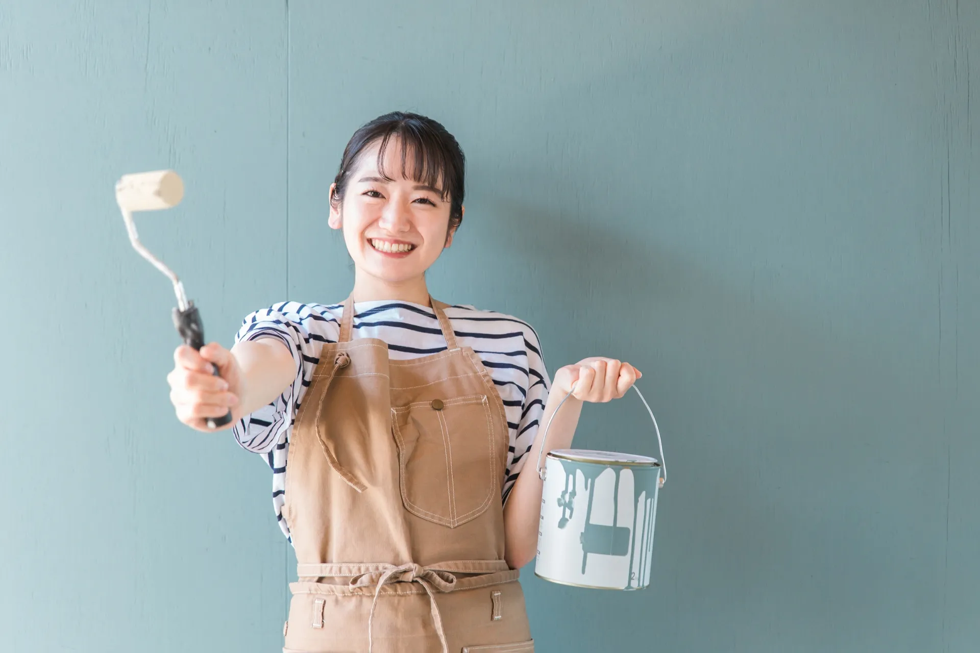DIYに適した塗料を持ち笑っている20代女性のイメージ画像
