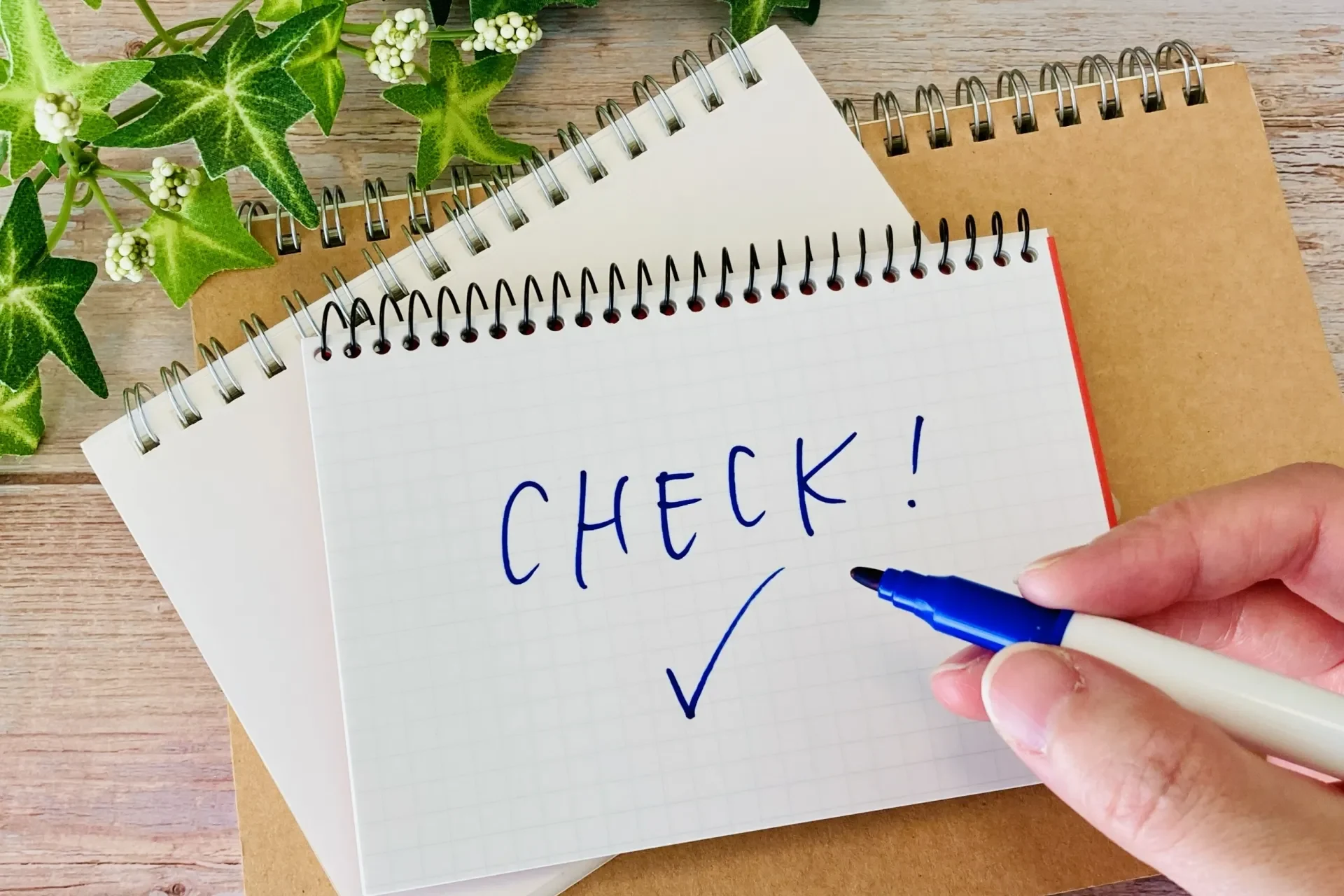 アルミサッシをDIYする際の下準備をチェックする人の手とメモ帳のイメージ画像
