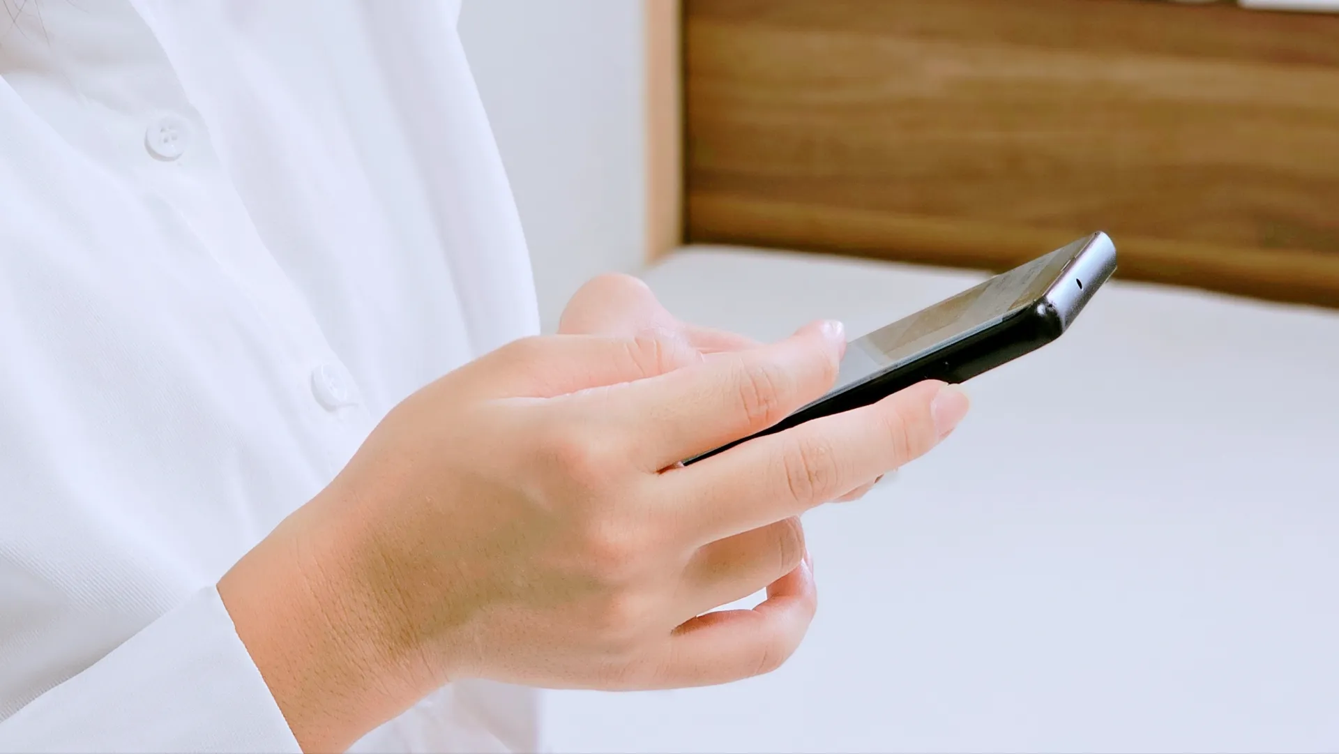 埼玉県で塗装する場合の費用相場をスマートフォンで調べる人の手元のイメージ画像